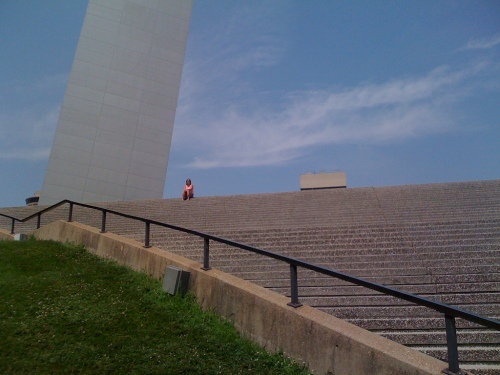 Person sitting on stairs leading up to the Arch. Photo by Michael L. Shaw. 